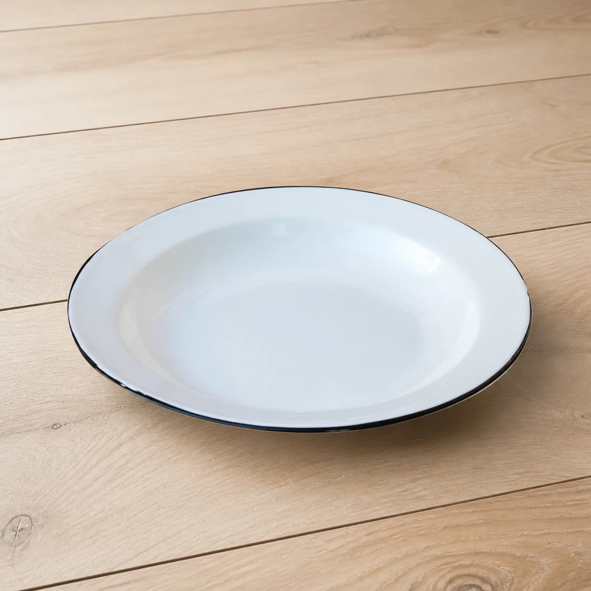 White Enamel Dinner Plate staged in a curated room setting one.