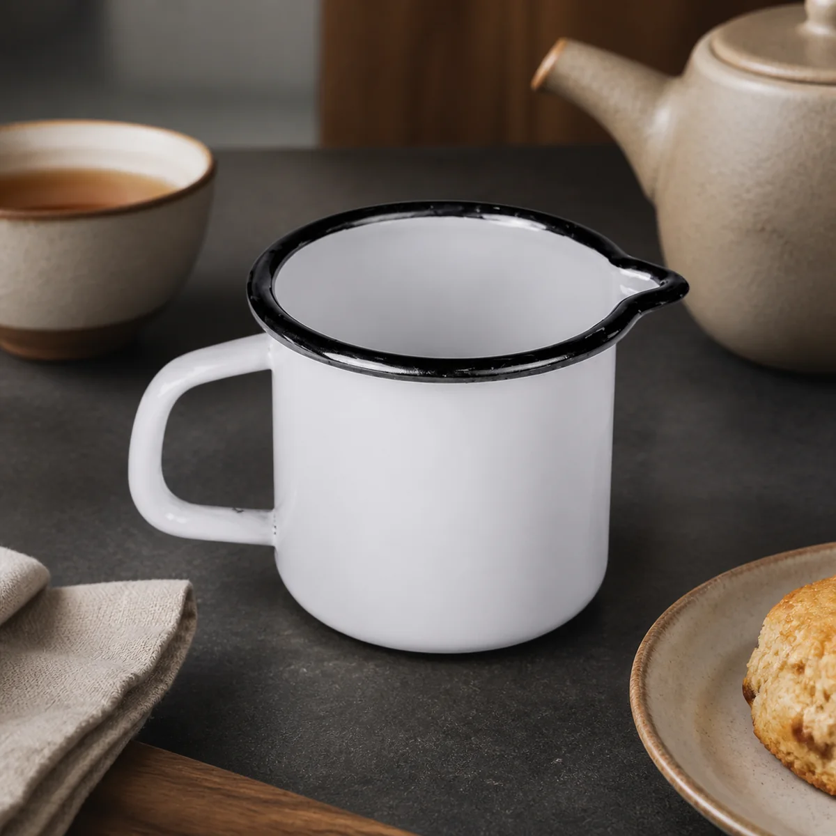Grey Enamel Creamer staged in a curated room setting one.