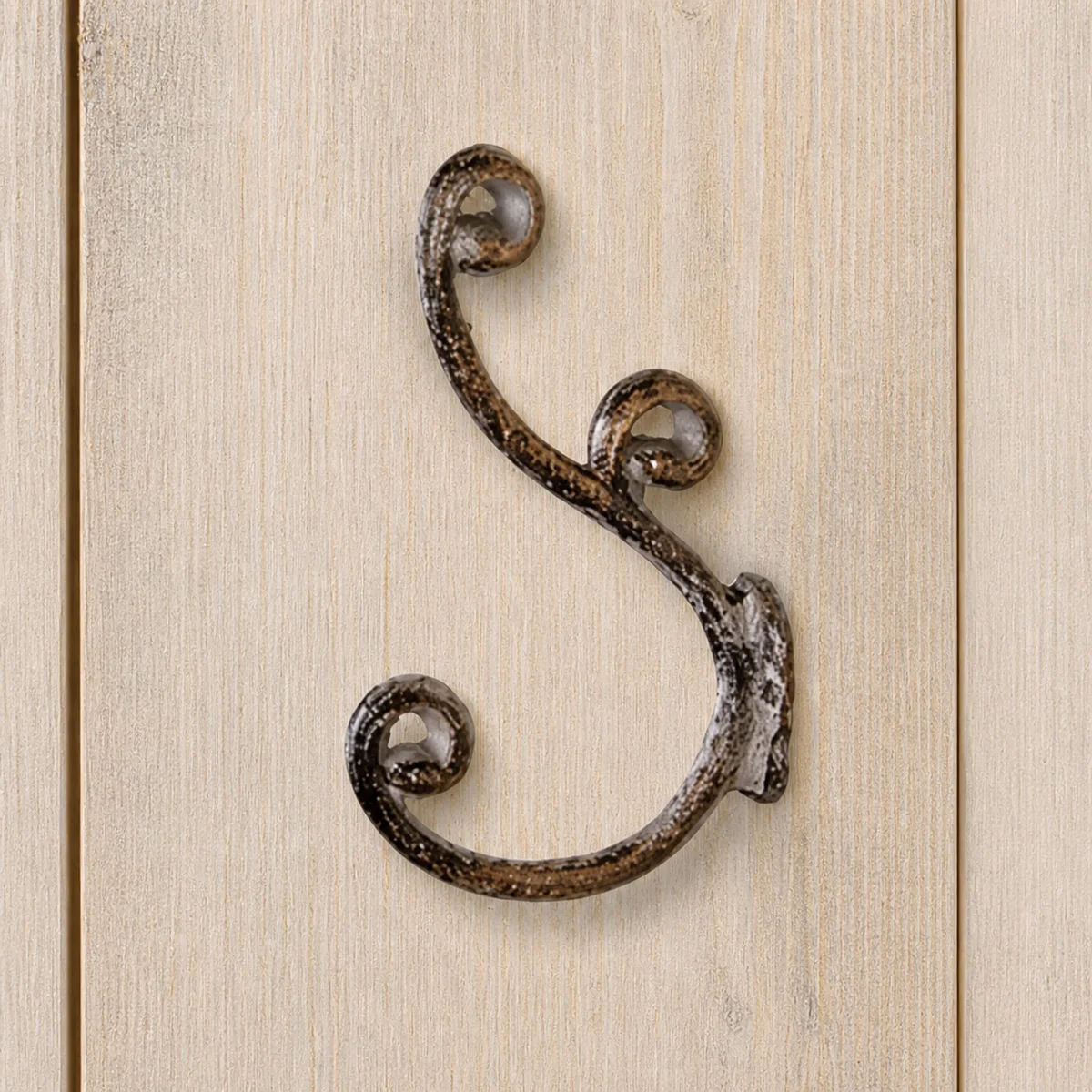 Antiqued Pewter Scroll Double Wall Hook staged in a curated room setting one.