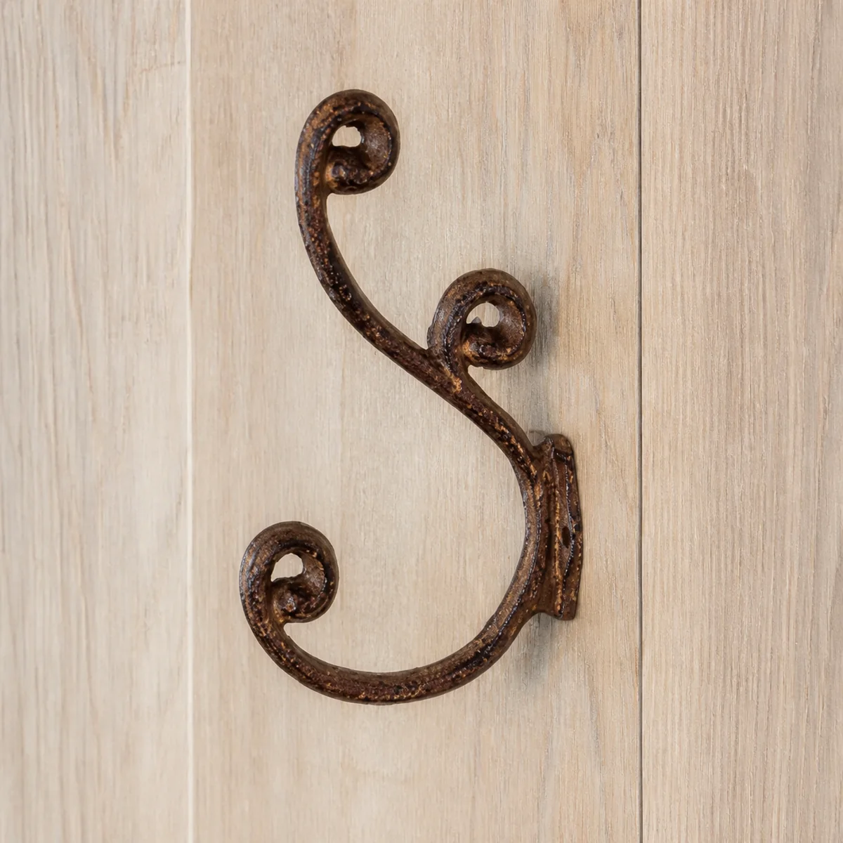 Rust Scroll Double Wall Hook staged in a curated room setting one.