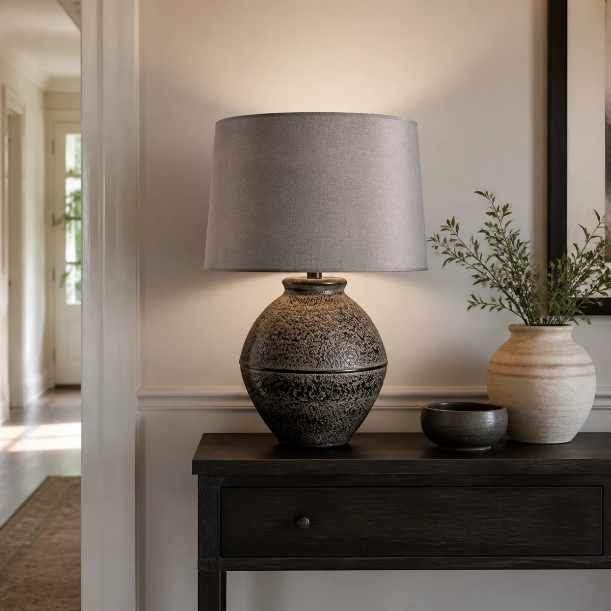 Burnished Urn Table Lamp staged in a curated room setting one.